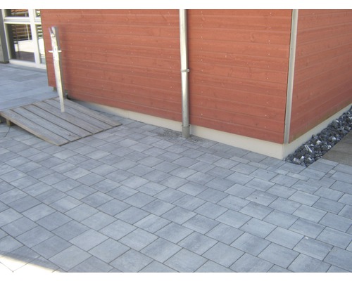 Cour pavée avec rampe en bois et mur en bois