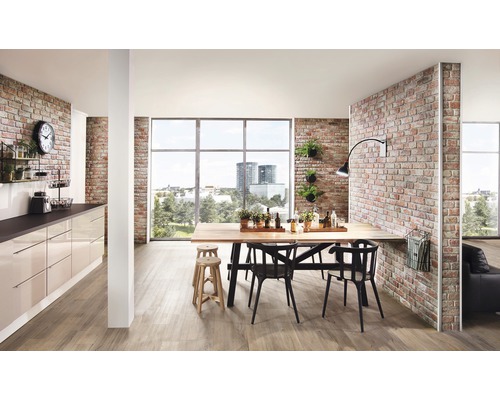 Pièce à vivre lumineuse avec table à manger, chaises, kitchenette et mur de briques