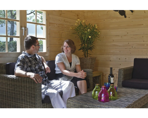 Scène d''intérieur avec un couple sur un canapé en rotin dans une cabane en bois