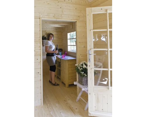 Vue intérieure d''une maison en bois avec femme, comptoir et porte partiellement ouverte