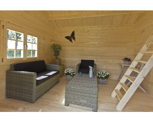 Intérieur d''une maison en bois avec canapé, fauteuil, table et échelle