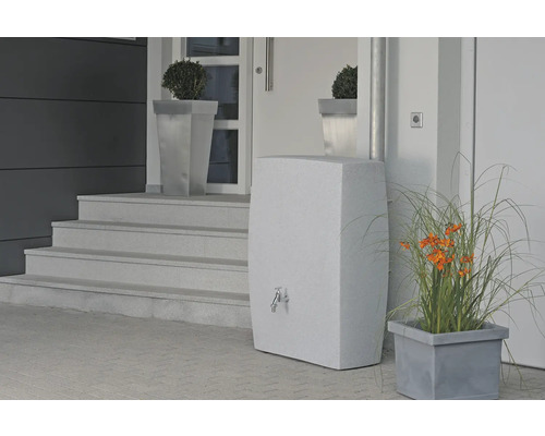 Prise de vue d''une façade de maison avec un réservoir d''eau élégant avec robinet, flanqué de jardinières avec des plantes