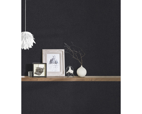 Detailansicht einer schwarzen Wand mit Dekoration auf einem Regal