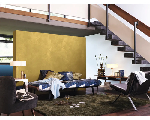 Wohnzimmer mit Couch, Sessel, Teppich und Treppe.