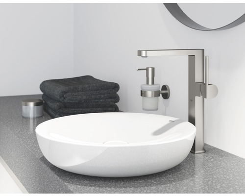 Aufsatzwaschbecken mit Armatur, Seifenspender und Handtüchern im Badezimmer