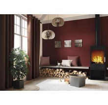 Wohnzimmer mit Kamin, Brennholz, Vorhängen und Zimmerpflanze