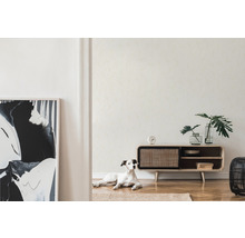 Wohnraum mit gemusterter Tapete, Anrichte und Hund