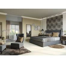 Chambre avec lit, fauteuil et baignoire à l''arrière-plan