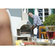 Un homme fait griller des aliments à l''extérieur avec un barbecue de jardin