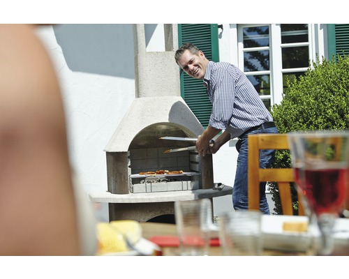 Mann grillt mit einem Gartengrill Lebensmittel im Freien