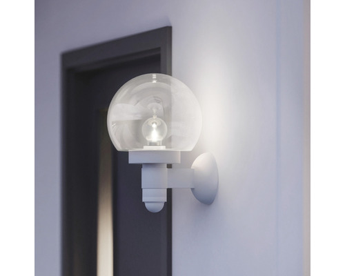 Wandleuchte mit runder Glaskugel in einem hellen Raum neben einer Tür