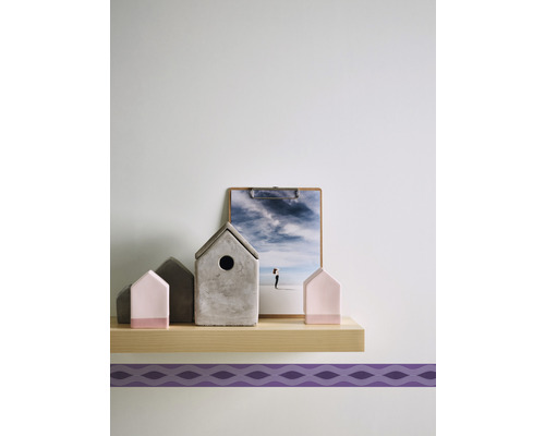 Dekorative Miniaturhäuser und ein Bild auf einer Ablage.