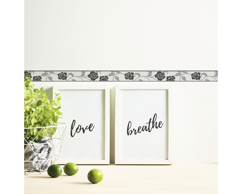 Bordure murale à motif floral au-dessus de deux tableaux encadrés avec les mots Love et Breathe.