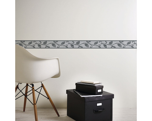 Wandbordüre mit Blättermuster im Raum mit Stuhl und Aufbewahrungsboxen