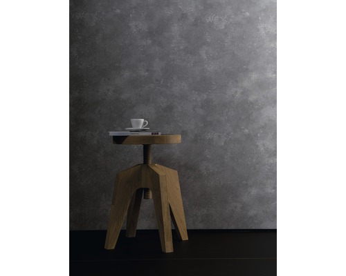 Dekorative Szene mit Holzhocker, Buch und Tasse vor einer grauen Wand