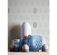 Divers vases sur une surface devant un papier peint à motifs