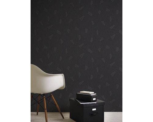 Raumansicht mit dunkler gemusterter Tapete, weissem Stuhl und schwarzer Aufbewahrungsbox