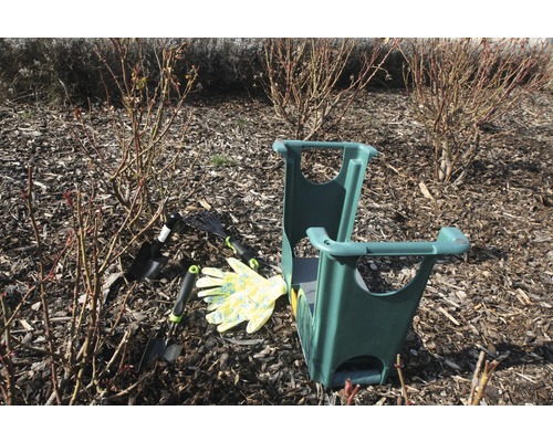 Scène de jardin avec agenouilloir, outils de jardin et gants de jardinage