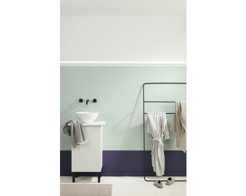 Salle de bains avec lavabo sur meuble bas, porte-serviettes avec textiles et tapis de bain