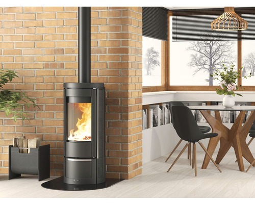 Poêle à bois dans un salon lumineux avec mur en briques et coin repas.