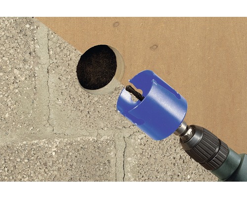 Perceuse avec scie cloche perçant un trou dans un matériau