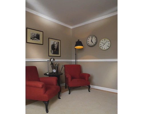 Deux fauteuils rouges avec table d''appoint, lampadaire et horloges murales dans un salon