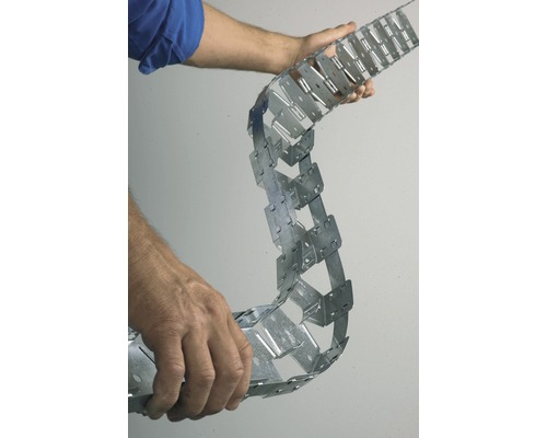 Une personne tient une bande à clouer perforée en métal.