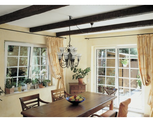 Esszimmer mit Holztisch, Stühlen, Fenstern und Vorhängen