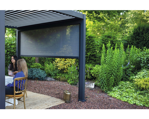 Pergola avec protection visuelle abaissée et personnes assises dans le jardin