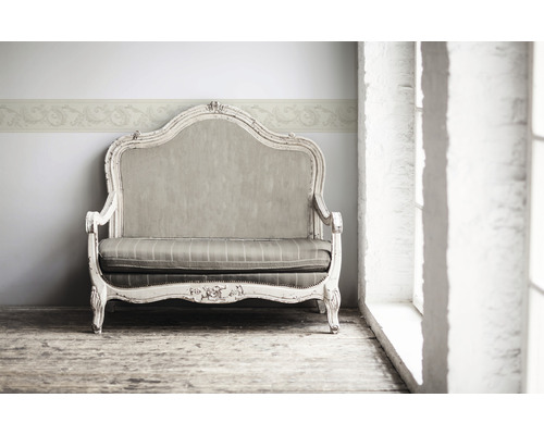 Dekoratives Sofa mit floraler Bordüre an der Wand für ein elegantes Raumambiente.