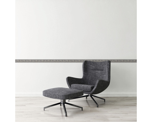 Wohnraum mit Zierbordüre und Sessel mit Fusshocker