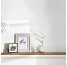 Bordure décorative dans une pièce avec cadres photo, vase et lampe.
