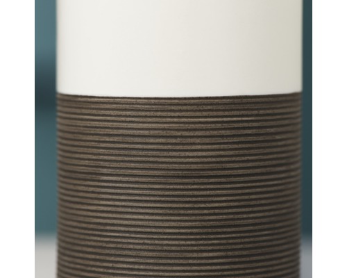 Detailaufnahme einer Vase mit geriffelter Struktur im unteren Bereich und glatter Oberfläche im oberen Bereich
