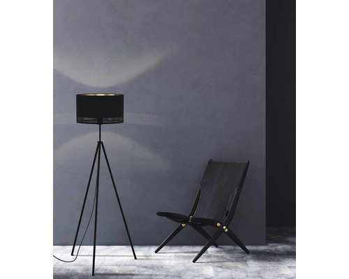 Stehleuchte und Stuhl aus Holz vor einer Wand