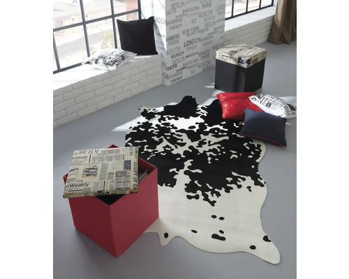 Pièce décorative avec tapis imitation peau de vache, cubes d''assise et coussins