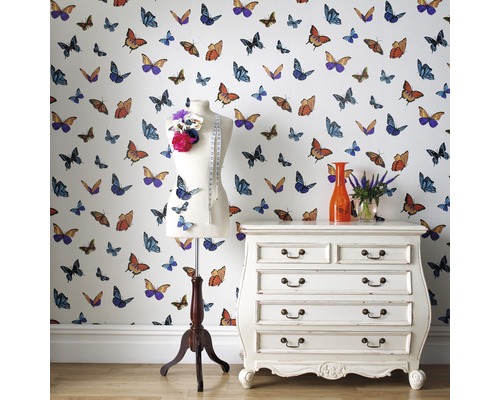 Pièce lumineuse avec papier peint à motifs de papillons, un mannequin de couture, une commode à tiroirs et des fleurs