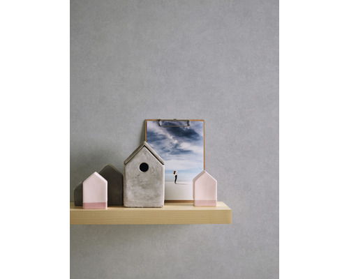 Dekorative Häuser aus Beton und Holz auf einem Holzregal mit einem Klemmbrett mit Landschaftsbild