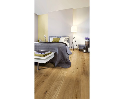 Schlafzimmer mit Holzboden, Bett und Beistelltisch