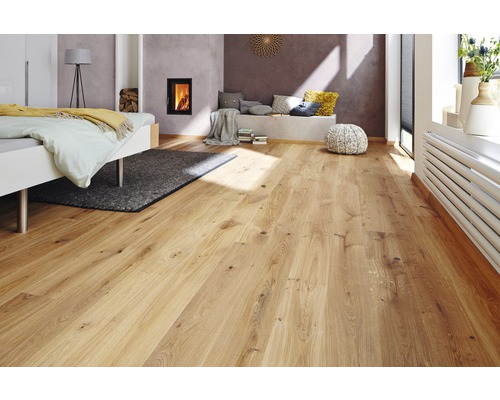 Plancher en bois clair dans une chambre avec lit et cheminée