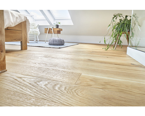 Plancher en bois clair posé dans une chambre sous un velux