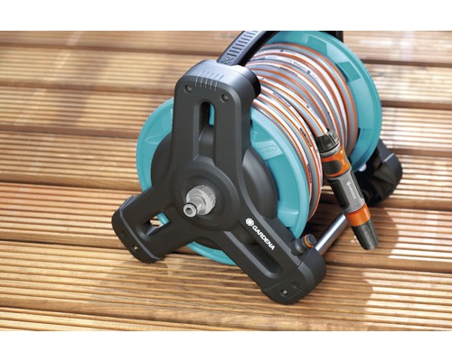 Dévidoir Gardena avec tuyau d''arrosage sur terrasse en bois