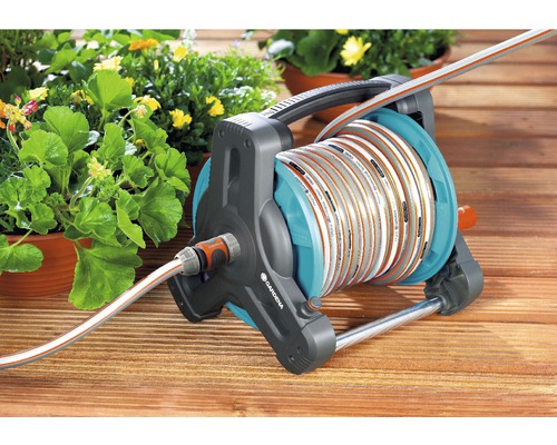 Dévidoir de tuyau Gardena avec tuyau sur terrasse en bois