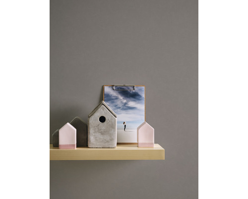 Maisons décoratives en béton et en bois sur une étagère avec une photo sur un presse-papiers.