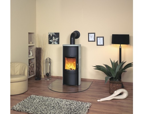 Salon avec poêle à bois, fauteuil, tapis et décoration