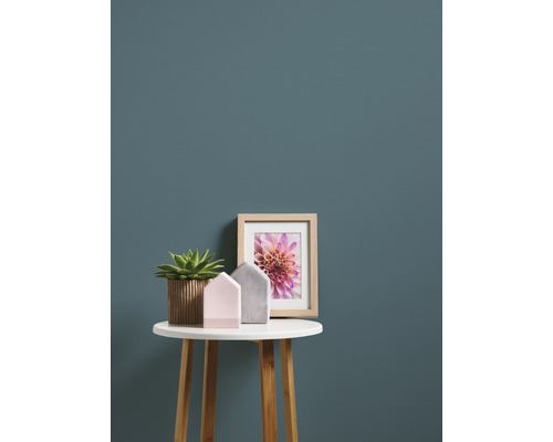 Décoration avec plante en pot, cadre photo et maisons décoratives sur une petite table.