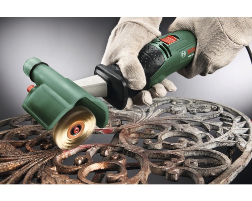 Eine Person mit Handschuhen verwendet eine Bürstenmaschine von Bosch zum Reinigen einer verzierten Metalloberfläche.