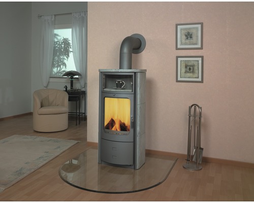 Poêle à bois dans le salon avec accessoires et plaque de verre