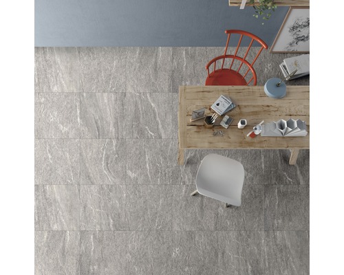 Motif de carreaux gris posé dans une pièce avec table et chaises en vue plongeante.