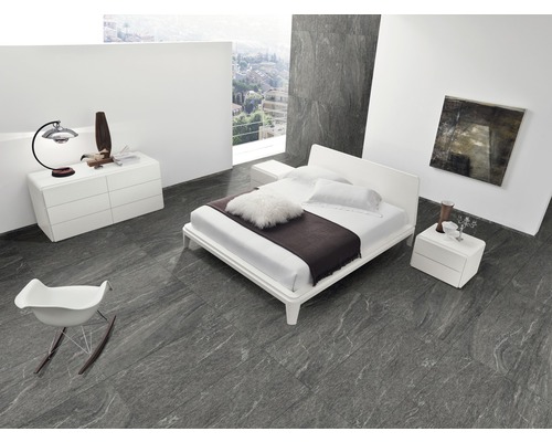 Chambre lumineuse avec lit double, table de chevet, commode et fauteuil sur un sol carrelé gris