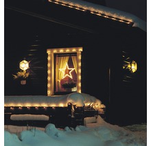 Hausfassade mit weihnachtlicher Beleuchtung und Stern im Fenster